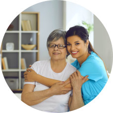 a female nurse hugging an elderly woman